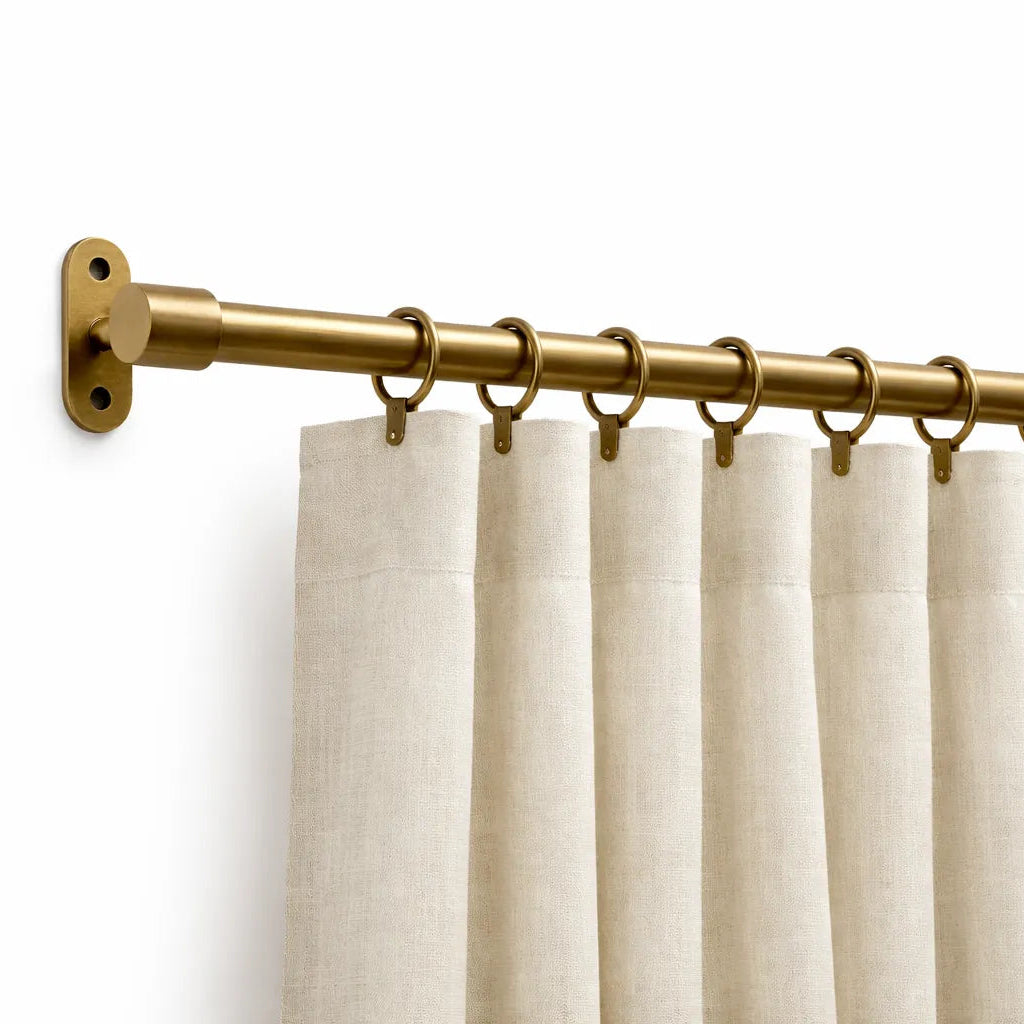Beige curtains with a gold curtain rod on a white background