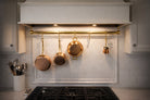 Kitchen with copper pots and pans hanging above a stove