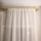 White curtain with gold rod on a white wall